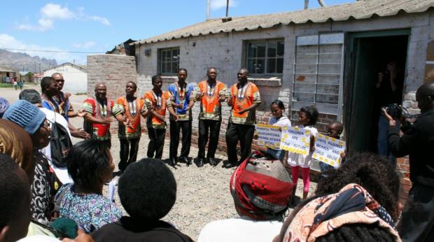 Members of the community of Lwandle join to celebrate the opening of the newly restored "Hostel 33" exhibit funded by the U.S. Ambassadors Fund for Cultural Preservation. Photo credit: United States Diplomatic Mission to South Africa website.