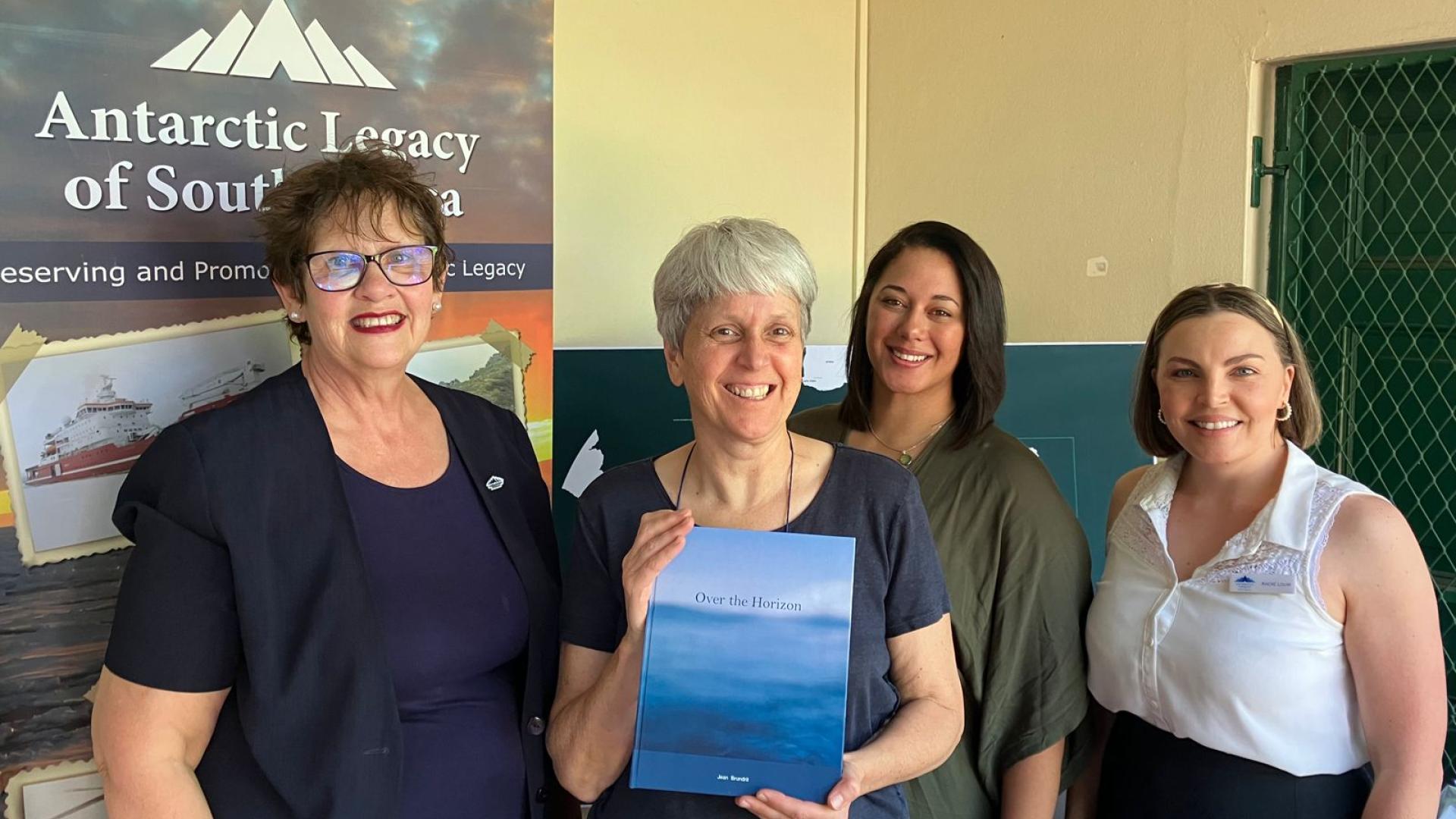 Jean Brundrit holding a copy of her book Over the Horizon